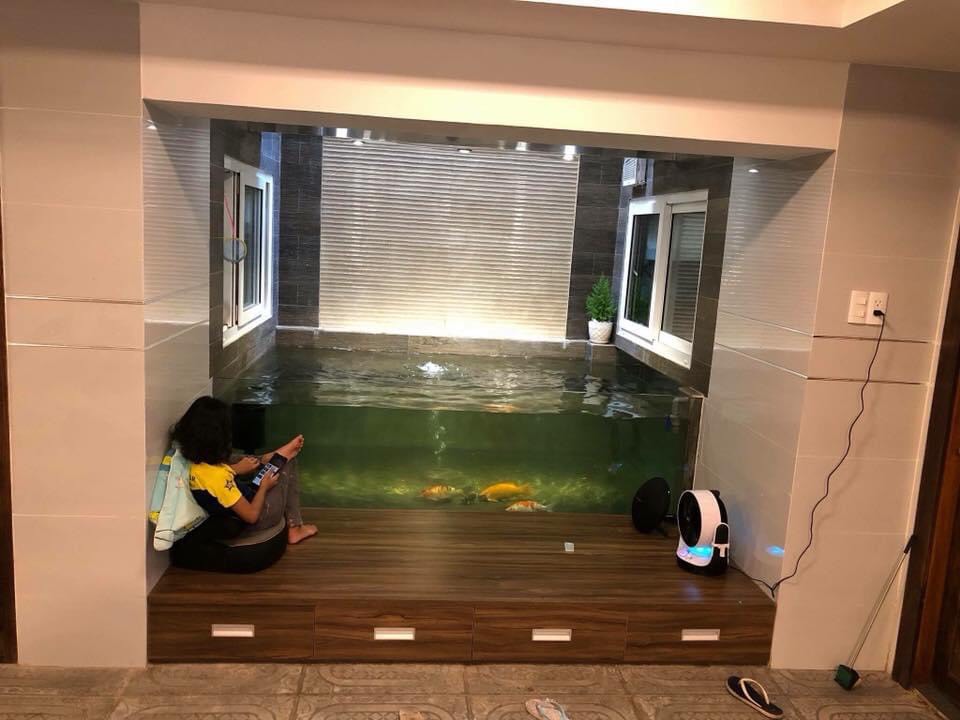 Tầng hầm bố trí hồ cá KOI có bục ngồi tạo thêm không gian chơi cho trẻ con trong nhà